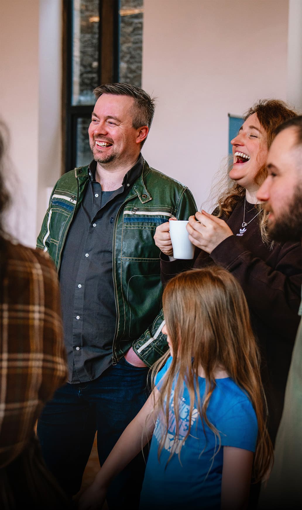 Pastors Struan and Abigail Wardlaw laughing over coffee with the church family
